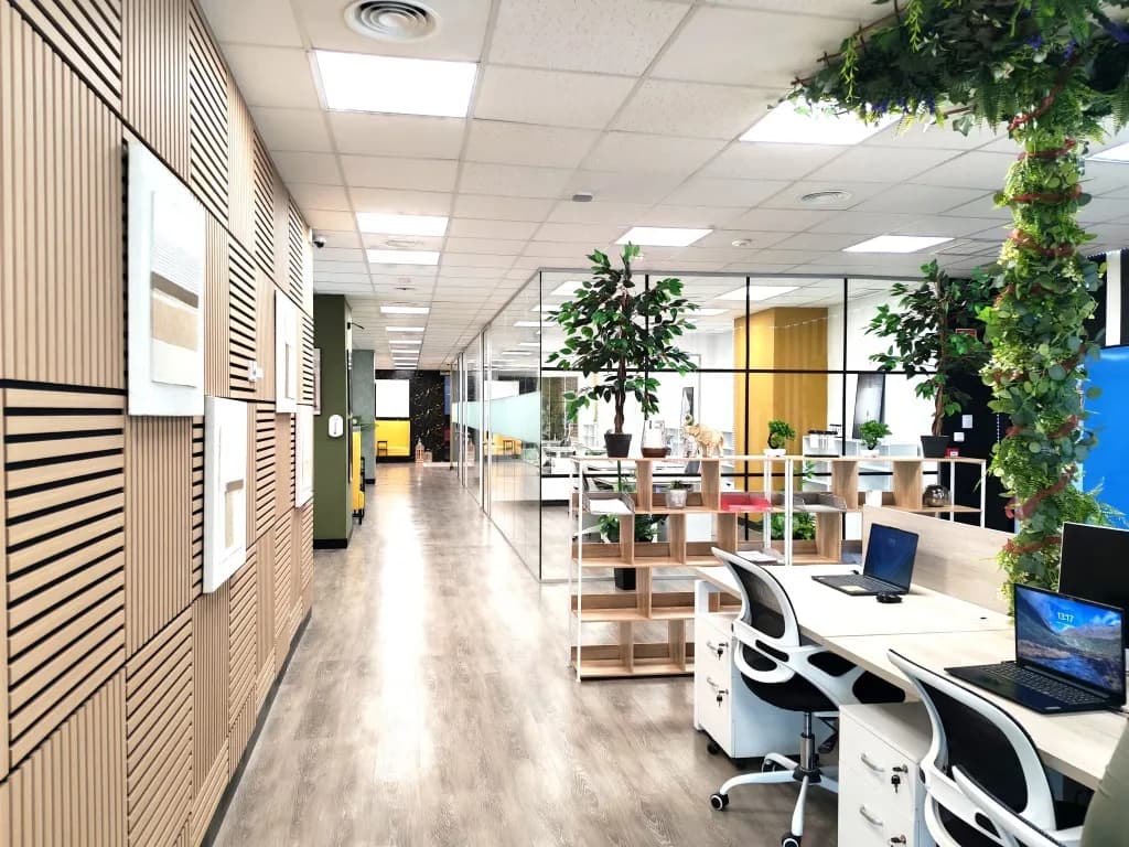 Puestos de coworking junto a los despachos acristalados