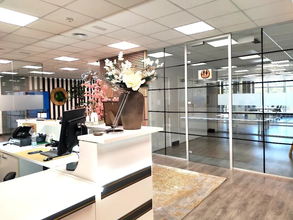 Recepción con pared de listones y acceso acristalado