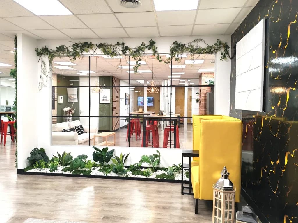 Zona común con jardinera, cristalera y sillón amarillo